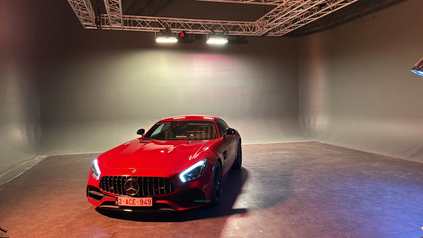 Une Mercedes rouge sur le cyclorama Carmaxx, sous la structure d’éclairage